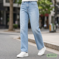 Person wearing light blue jeans and sneakers on a street, waist down